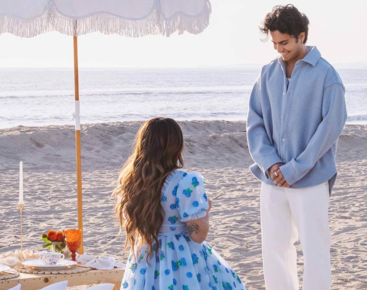 woman proposing to man on beach